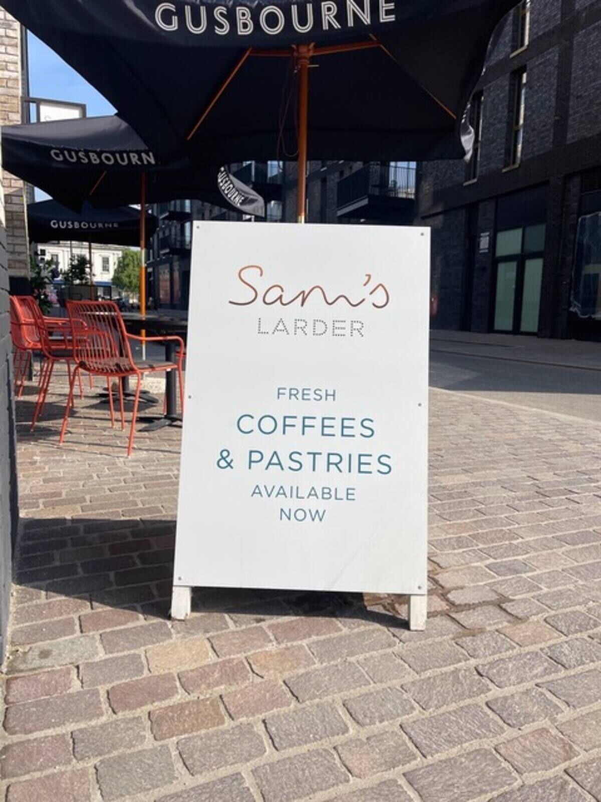 «Sam’s Larder» -liikkeen kyltti, jossa mainostetaan tuoretta kahvia ja leivonnaisia, joita on nyt saatavilla.