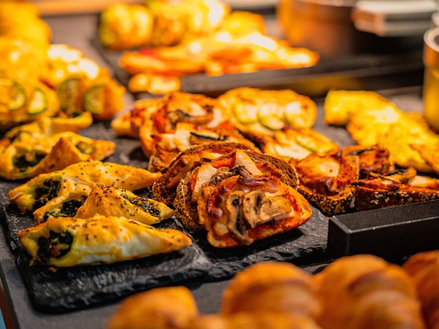 Variedad de productos horneados en una bandeja, incluyendo pasteles y pan.