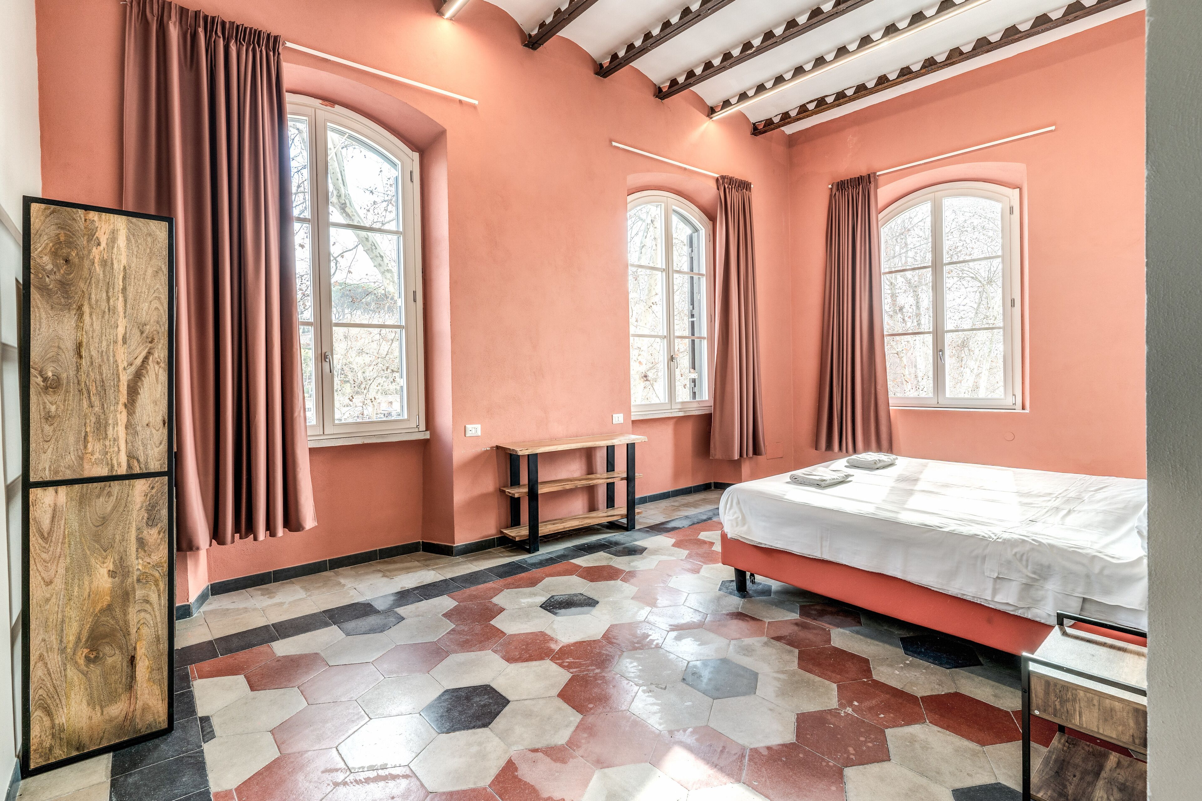 Un dormitorio con una cama, un armario de madera y un banco.