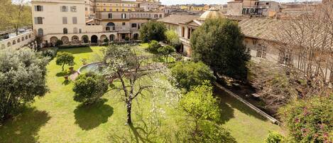 Un patio con una fuente, rodeado de edificios con ventanas de arco y una estructura en forma de cúpula.