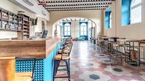 A bar area with a long counter, multiple stools, and a patterned floor. - Borgo Ripa Urban Travel (Rome)