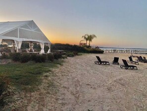 Relax on the beach with lounge chairs and enjoy dining under a spacious tent.