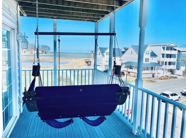 Relax on the porch with a swing suspended by chains, offering a view of the surrounding neighborhood.