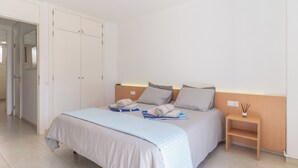 A bedroom with a bed, a bedside table, a nightstand, and a wardrobe. - GO2TENERIFE Apart’Vera Duplex Santiago 2 (Costa Adeje)