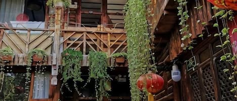 A traditional wooden building with hanging plants and red lanterns.