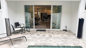 A pool area with a sliding glass door leading to a dining area.