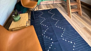 Camera mansardata con una scala in legno, un letto verde, una scrivania e una sedia.