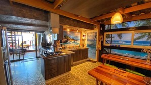 A kitchen with a gas stove, wooden cabinets, and a patterned tile floor. - Pacific Sunset Reñaca (Vina del Mar)