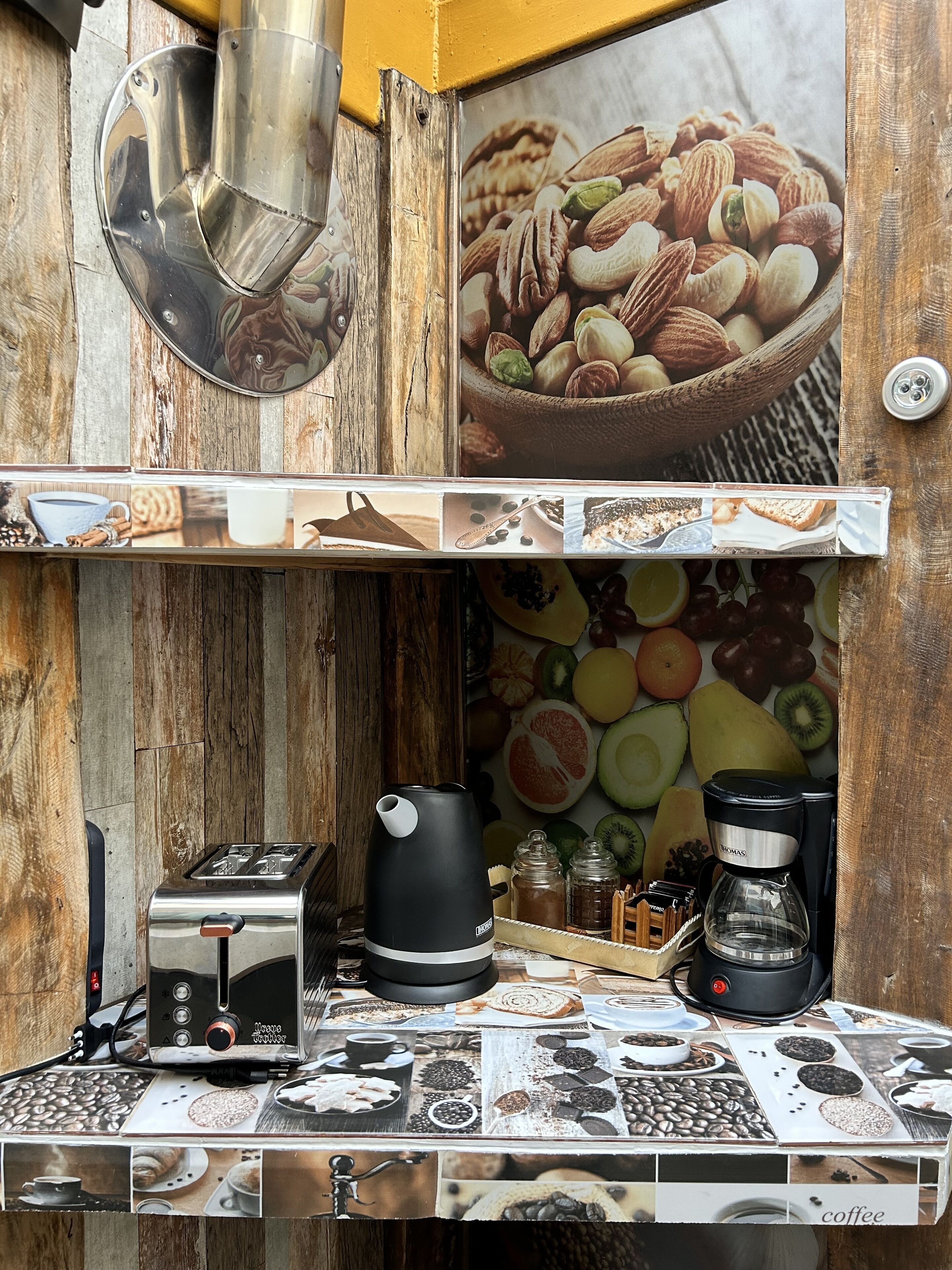 Una cocina con cafetera, tostadora y diversos alimentos.