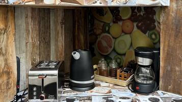 Una cocina con cafetera, tostadora y diversos alimentos.