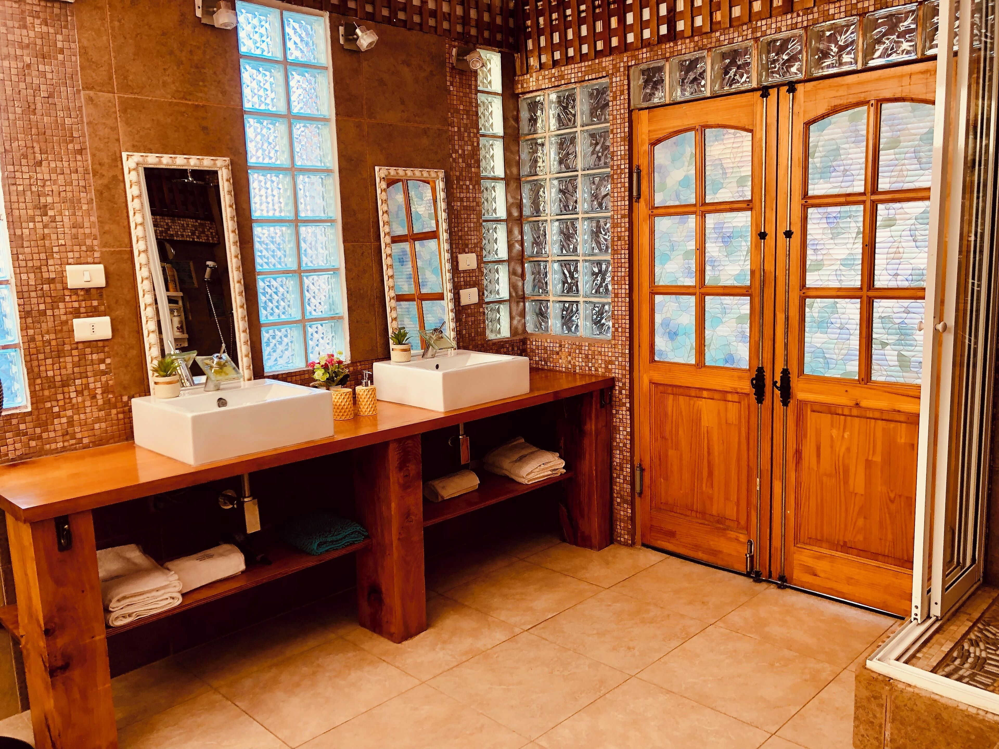 A bathroom with two sinks, a mirror, and a wooden door.