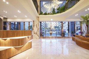 A modern hotel lobby with a curved reception desk, a central glass partition, and a view of the cityscape. - Zela Design Hotel (Kaohsiung)