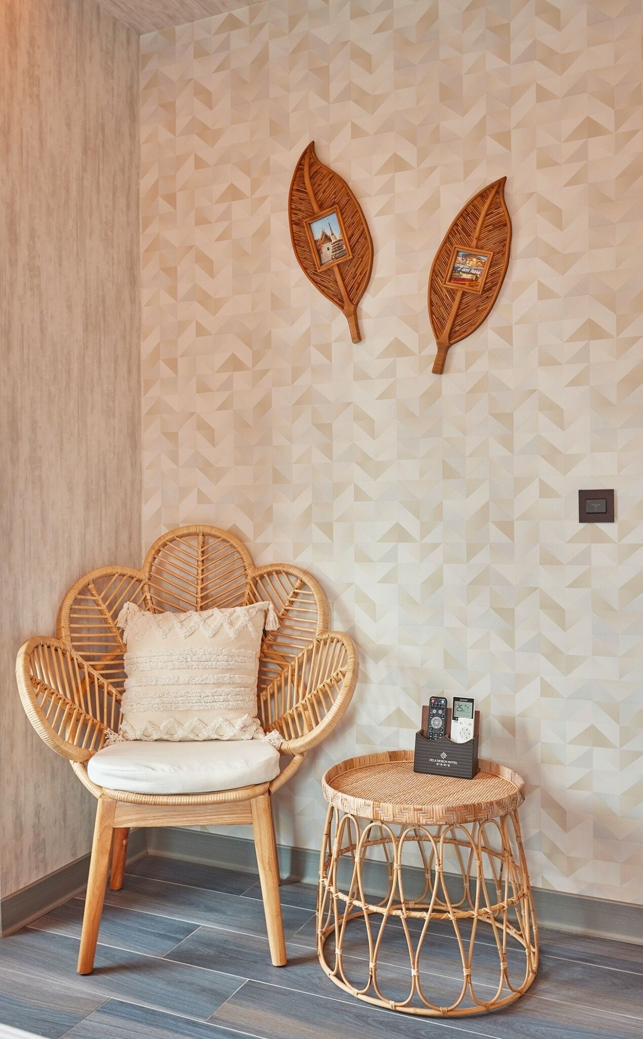 A room with a rattan chair and a small round table, both with cushions.