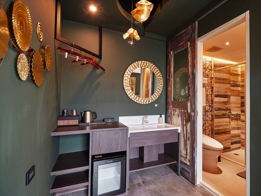 A modern bathroom with a built-in dishwasher, a large mirror, and a shower with wooden paneling.