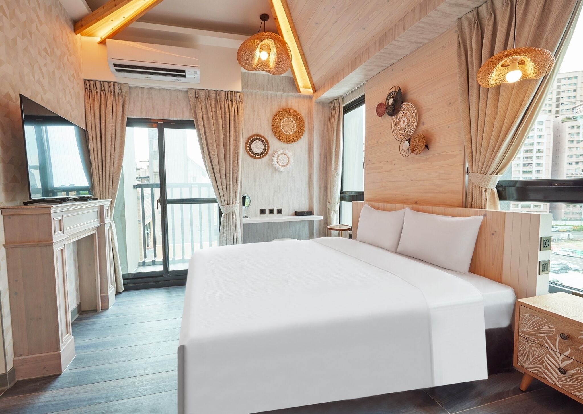 A modern hotel room with a large bed, wooden ceiling beams, and a balcony with curtains.