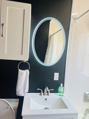 Bathroom features a sink, mirror, and towel.