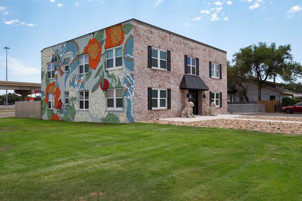 Stunning building with a vibrant dragon mural and floral patterns adorns the exterior, complemented by a charming entrance and beautifully manicured lawn.