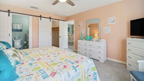 A bedroom with a bed, dresser, and television. - Cocoa Beach Vacation Rental - Walk to Pier! (Cocoa Beach)