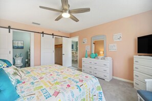 A bedroom with a bed, dresser, and television. - Cocoa Beach Vacation Rental - Walk to Pier! (Cocoa Beach)