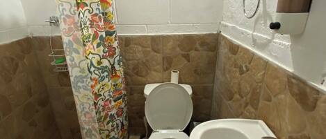 A bathroom with a toilet, sink, and shower curtain.