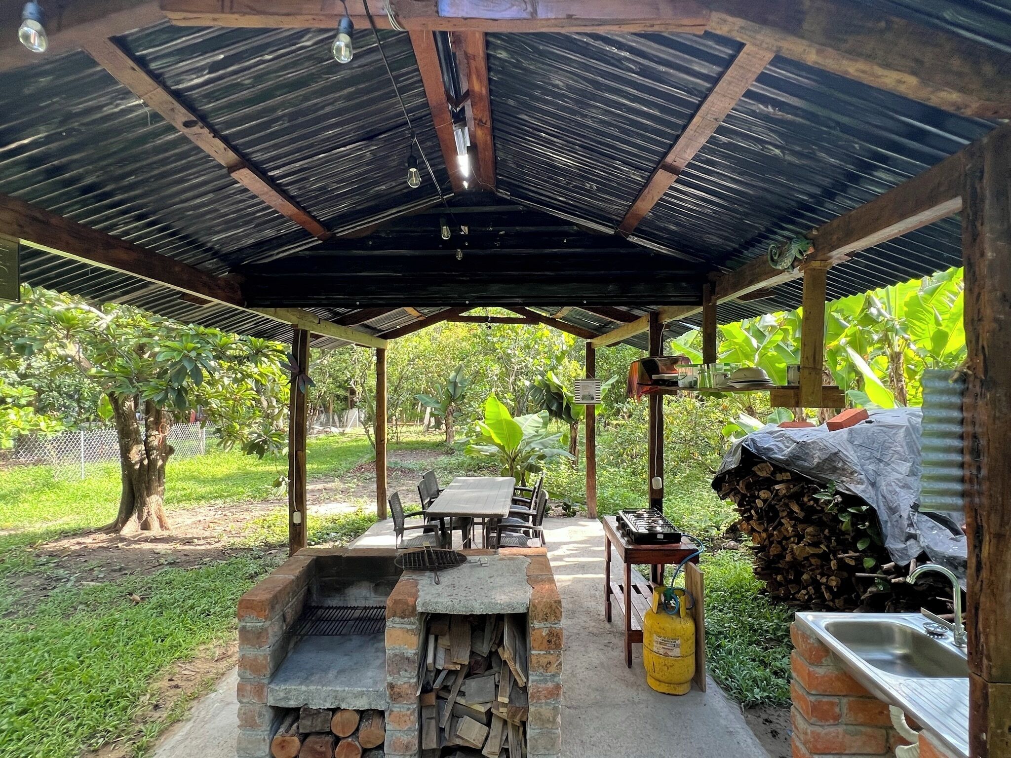 Eine Terrassenausstattung mit Grill, Sitzgelegenheiten und einem Gasbehälter.