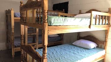 Un lit superposé avec une tête de lit en bois et un lit inférieur doté d’un matelas vert.