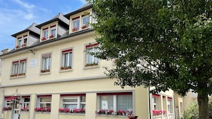 Un hotel de dos pisos con múltiples ventanas, algunas con jardineras.