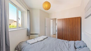 Une chambre à coucher avec un lit, une armoire et une fenêtre.
