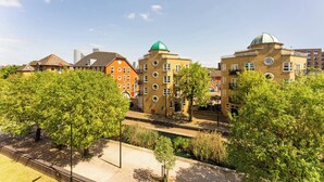 Un bâtiment à étages, doté de grandes fenêtres et surmonté d’un dôme vert.