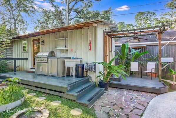 A small, rustic cabin with a patio area, a grill, and outdoor seating. - Relaxing garden cottage with sauna
(Shreveport)