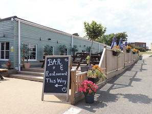 Un edificio rústico con un cartel que dice 'BAR & Restaurant This Way'.
