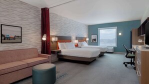 Een hotelkamer met een bed, een bank, een bureau en een televisie.