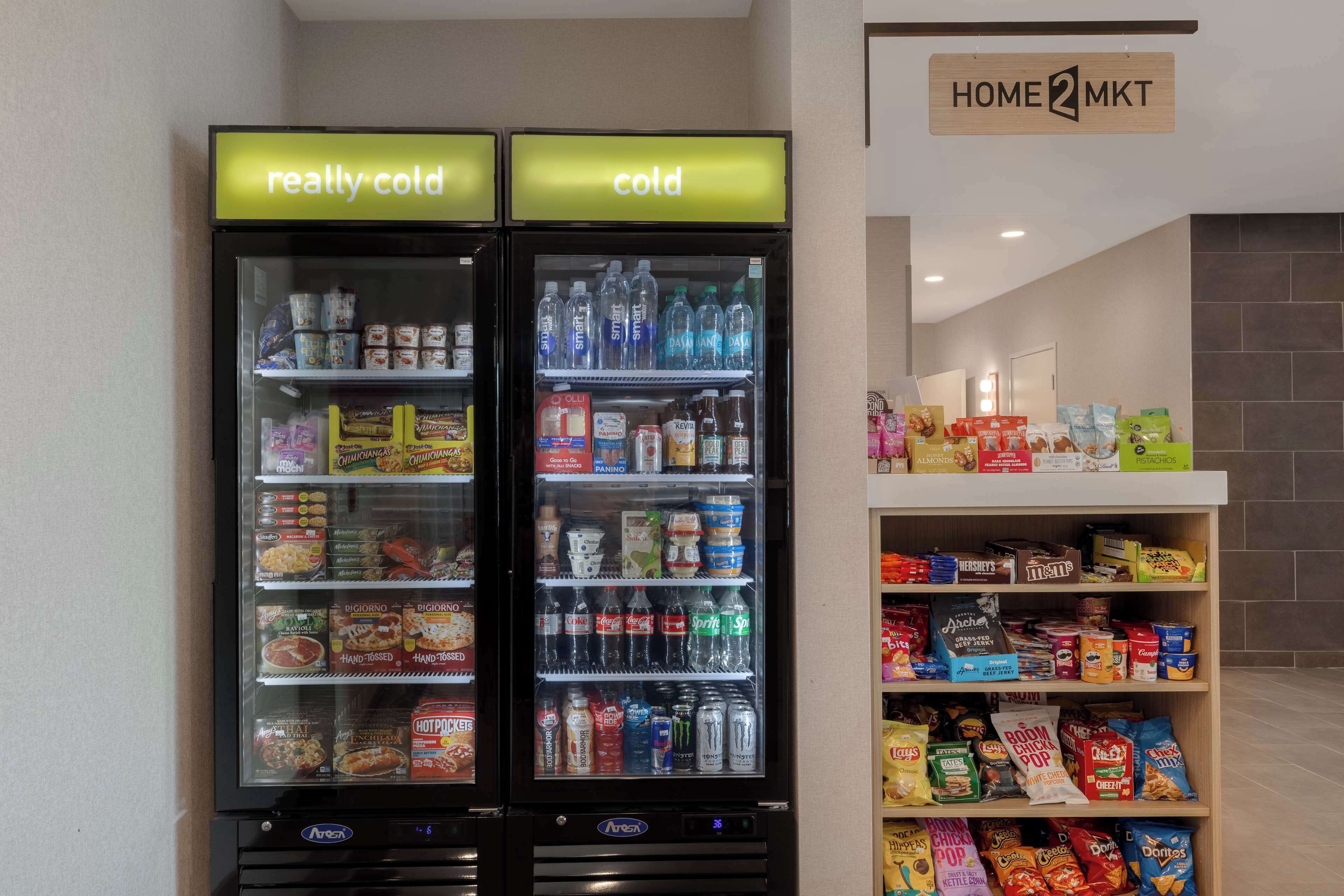 Deux distributeurs automatiques de boissons, l’un portant la mention « très froid » et l’autre « froid », proposant une variété de boissons et d’en-cas.