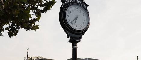 A historic clock in front of a building with a sign indicating it's a historic Birmingham Mineral Railroad Site.