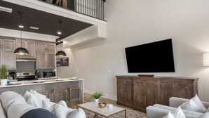 Een moderne woonkamer met een bank, salontafel en een wandgemonteerde flatscreen-tv.