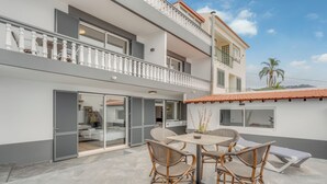A two-story building with a balcony, a dining area with wicker chairs, and a lounge chair. - Villa Winter Apt. 1 (Funchal)