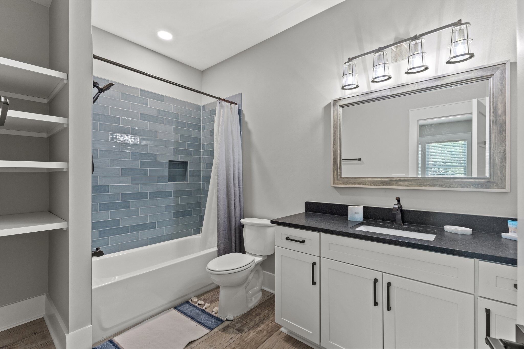 A modern bathroom with a shower, toilet, and sink.