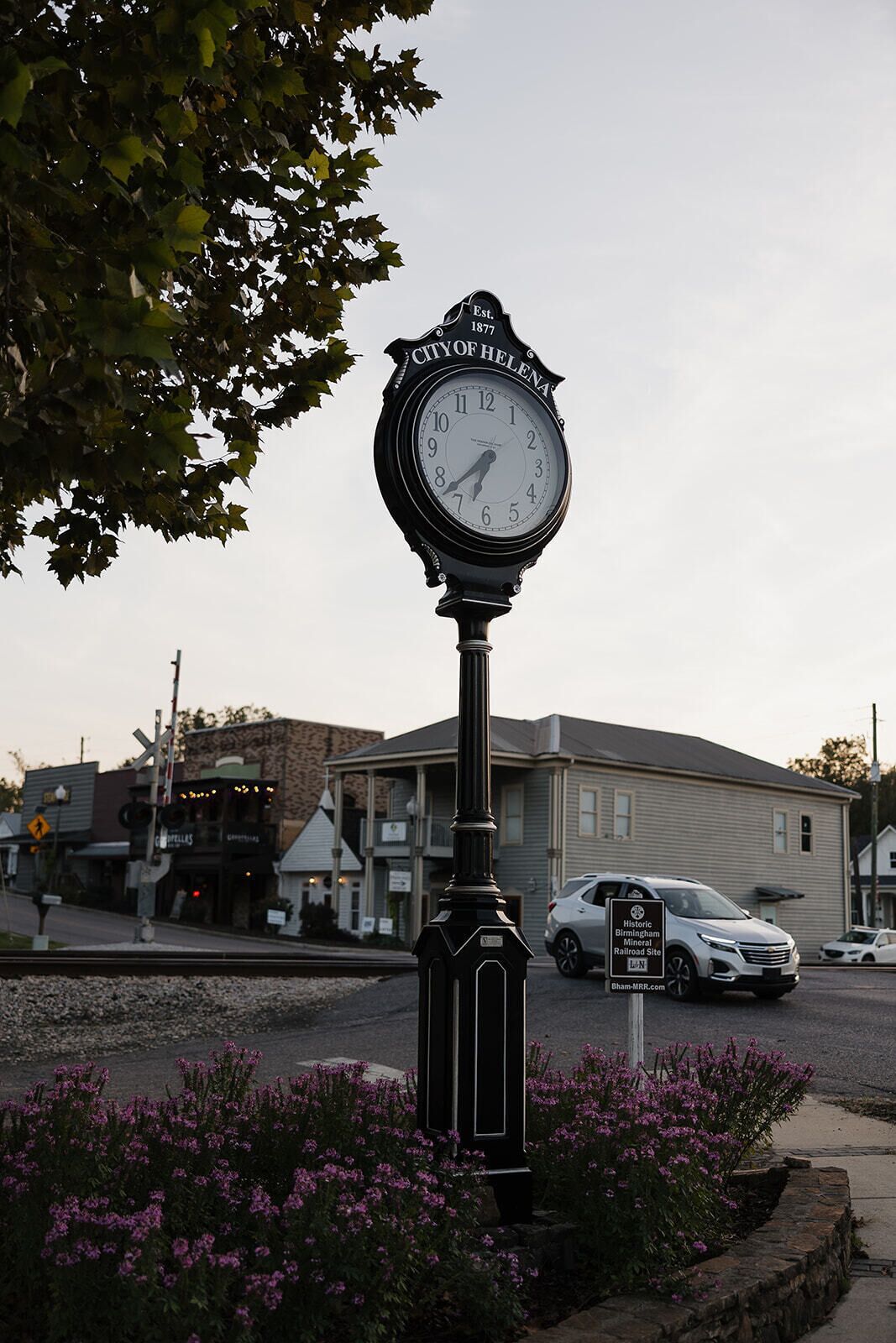 Un reloj histórico frente a un edificio con un cartel que indica que es un sitio histórico del Ferrocarril Mineral de Birmingham.