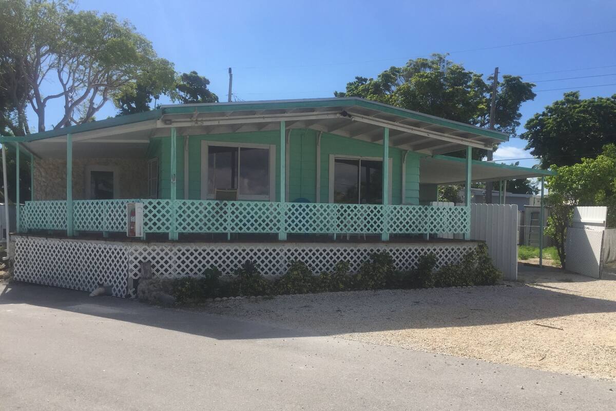A single-story house with a green exterior and a covered porch.
