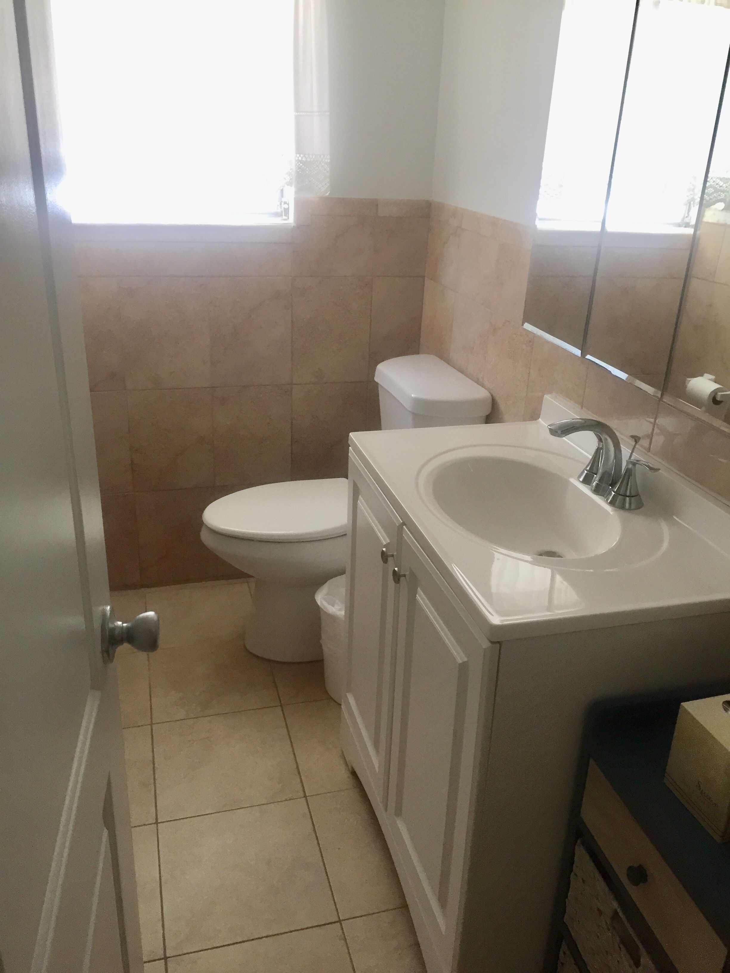 Une petite salle de bain avec des toilettes, un lavabo et un miroir.