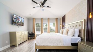 A bedroom with a bed, a dresser, a TV, and a ceiling fan. - Luxury Windsor Haven: 6BR Private Pool & Game Room (Kissimmee)
