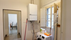 A laundry room with a washing machine, a dryer, and a water heater. - Oasis 2: Relaxation and Historicity in Pisa (Pisa)