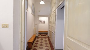 A narrow hallway with a wooden bench, a radiator, and a wall-mounted shelf. - Oasis 2: Relaxation and Historicity in Pisa (Pisa)
