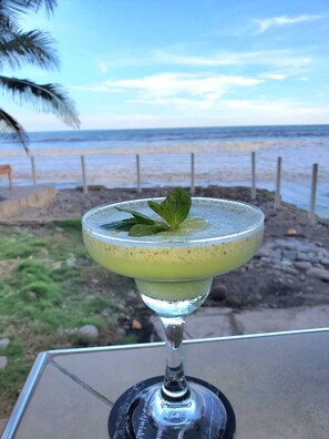 Un cocktail in un bicchiere con vista sulla spiaggia.