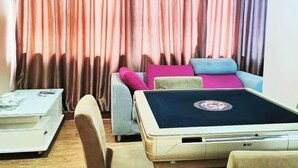 A room with a sofa set, a small table, and a curtain backdrop.