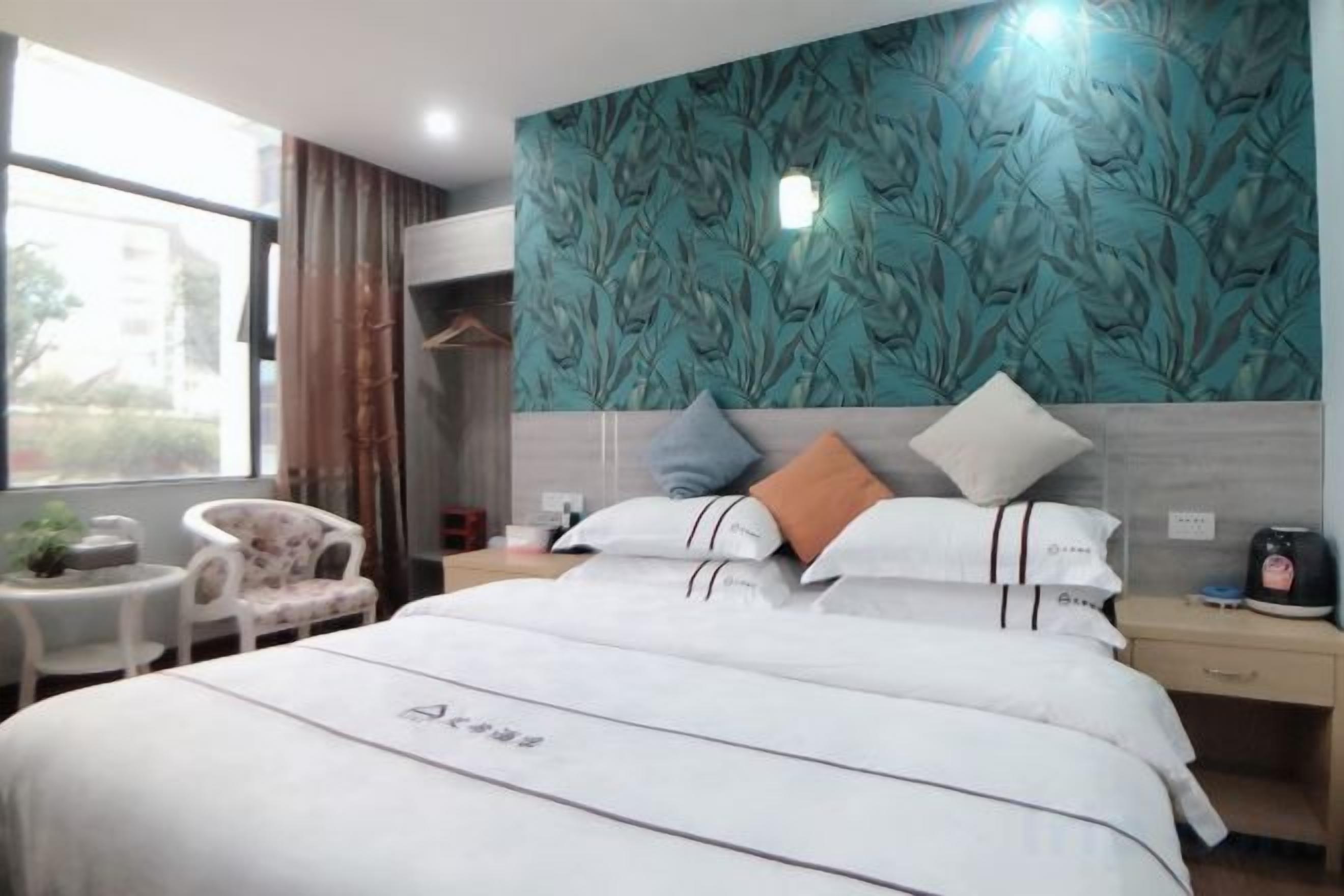 Une chambre d’hôtel avec un lit, une table de chevet, une chaise et une vue sur l’extérieur.