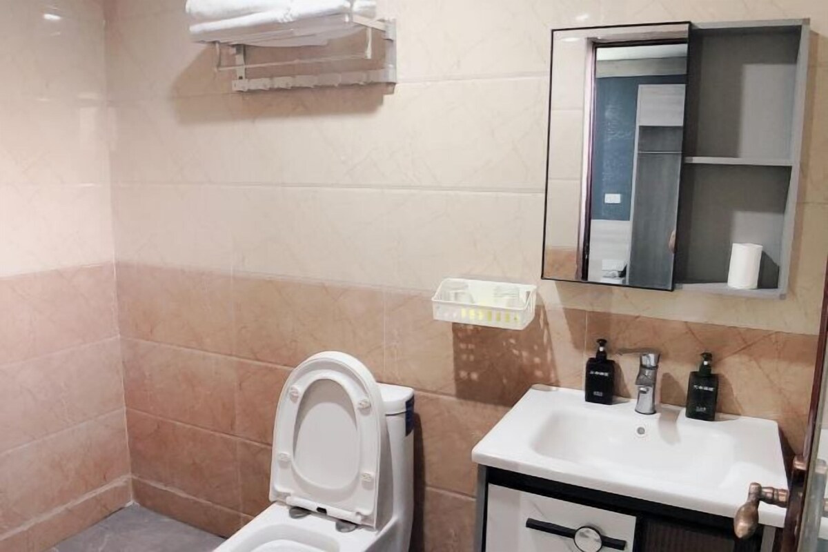 A bathroom with a toilet, sink, and mirror.