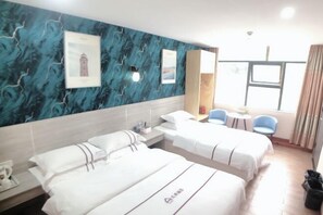 A hotel room with two beds, a large window, a blue patterned wall, and a small table with chairs. - AiXi Traving with hostel (Chongqing)