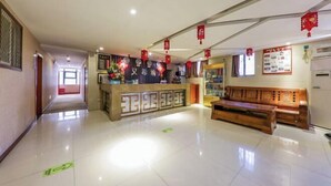 A hotel lobby with a reception desk, a wooden bench, and red lanterns. - AiXi Traving with hostel (Chongqing)