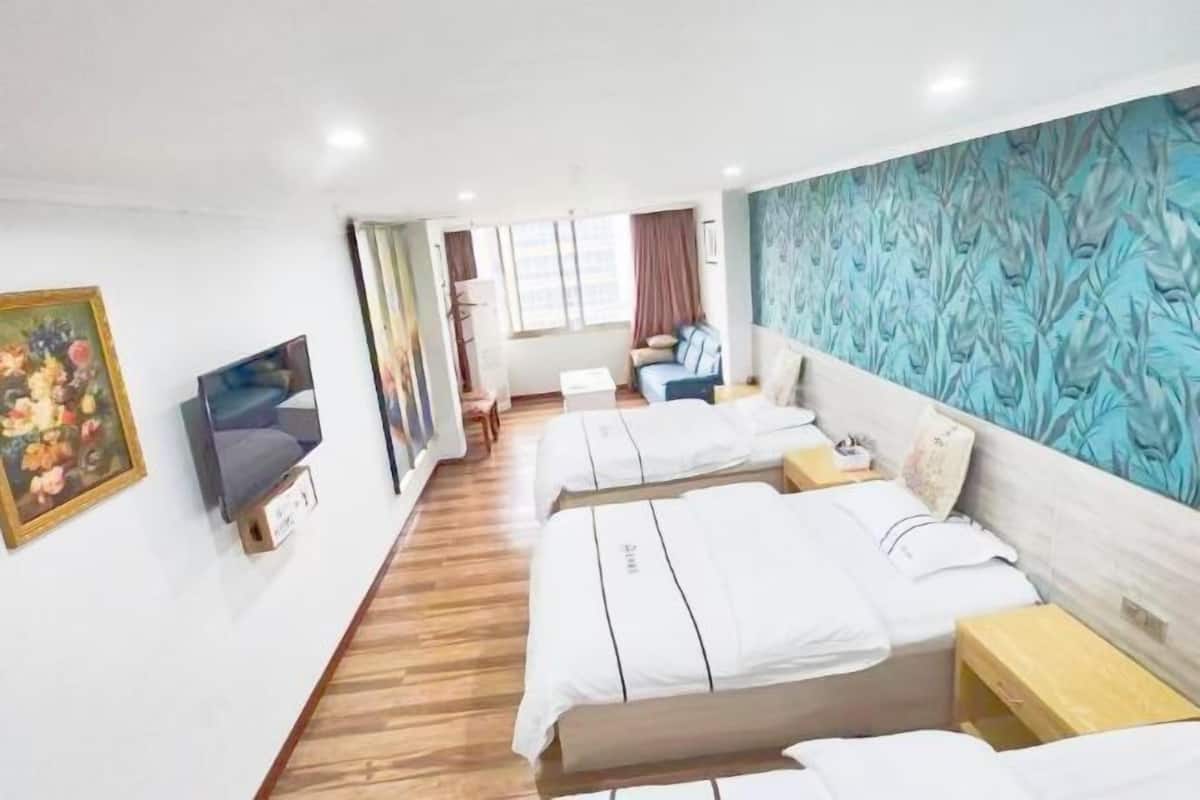 A hotel room with two beds, a television, a painting, and a window with curtains.